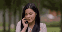 a woman in a white shirt is talking on her cell phone