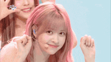 a girl with pink hair is holding a microphone and smiling