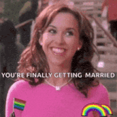 a woman in a pink shirt is smiling with the words you 're finally getting married
