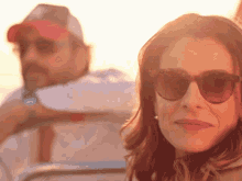 a woman wearing sunglasses and a man wearing a hat