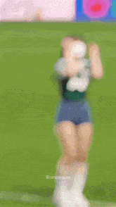 a blurry picture of a woman wearing a green shirt and a white shirt