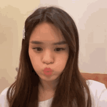 a woman with long brown hair is making a funny face