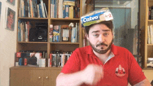 a man wearing a red shirt and a calvo packet on his head