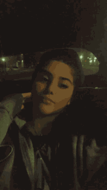a girl sitting in a car with her hand on her chin