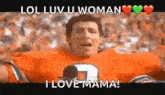 a man in an orange football jersey is holding a microphone and screaming .