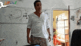 a man with a name tag that says alonso stands in front of a white board