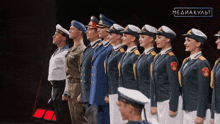 a group of men and women in military uniforms are standing in a line with a mediakult logo in the background