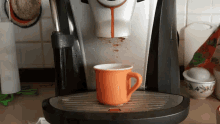 a cup of coffee is pouring out of a coffee maker