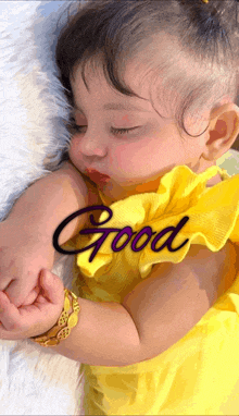 a little girl in a yellow dress is sleeping with the word good written above her