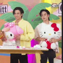 two men holding hello kitty stuffed animals in front of a c-vitt logo