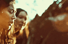 a couple of women are standing next to each other and looking at something .