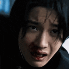 a close up of a person 's face with blood on it .