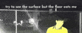 a man in a yellow shirt is standing in front of a chain link fence with the words try to see the surface but the floor eats me