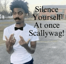 a man with a mustache and bow tie giving the middle finger with the words " silence yourself at once scallywag " behind him