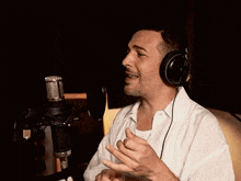 a man is singing into a microphone with headphones on