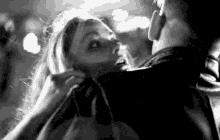 a black and white photo of a man and a woman fighting .