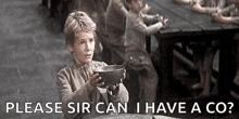 a young boy is holding a bowl with a spoon in it and asking if he can have a co .