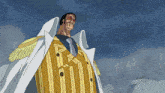 a man wearing a yellow and white striped suit and a white coat