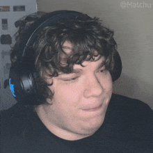 a man with curly hair wearing headphones with the hashtag @matchu on the bottom