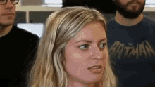 a woman wearing a batman t-shirt looks surprised