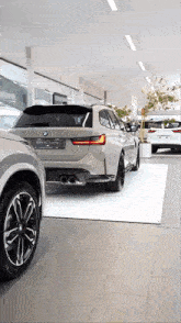 a bmw is on display in a showroom with other cars