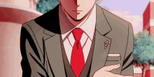 a man in a suit with a red tie has a pin on his jacket