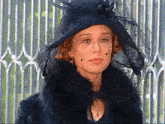 a woman wearing a black hat and a black fur coat