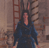 a woman in a blue robe with bunny ears is standing in a room