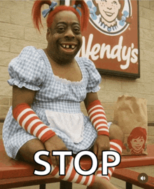 a wendy 's sign is behind a woman in a dress