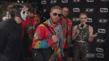 a group of people are standing in front of a wall that says aew on it