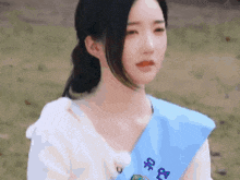 a woman wearing a sash that says ' u ' on it