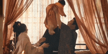 a man and a woman are holding a baby in their arms in a room .
