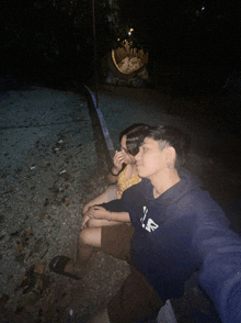 a person wearing a blue sweatshirt with the letter r on it sits next to another person