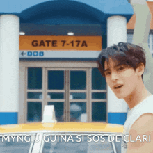 a man is standing in front of a building that says gate 7-17a on it