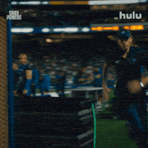 a woman running on a field with hulu written on the bottom