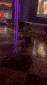 a man is kneeling down on a checkered floor in a room