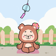 a cartoon of a teddy bear sitting in a lotus position with a wind chime above his head