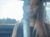a woman in a car is singing into a microphone .