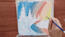 a person is painting a snowy landscape with trees