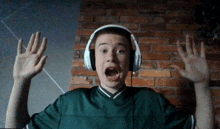 a man wearing headphones and a green shirt with his mouth open