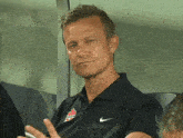 a man wearing a black shirt with a nike logo on it
