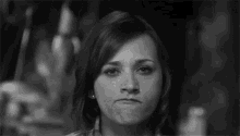 a woman is making a funny face with her mouth open in a black and white photo .