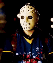 a man wearing a hockey mask and a blue shirt
