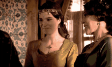 two women are standing next to each other and one has a necklace on