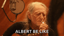 a man with long hair is smoking a cigarette and the words albert be like are above him