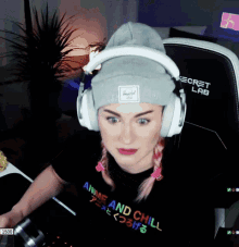 a woman wearing headphones and a beanie says anime and chill on her shirt