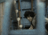 a man wearing a black hat is looking through a window