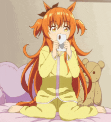 a girl with orange hair is sitting on a bed holding a phone