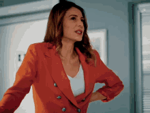 a woman in a red jacket stands in front of a window with the number 1 on it