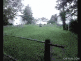 a gif from gifrun.com shows a fence in the foreground and a house in the background